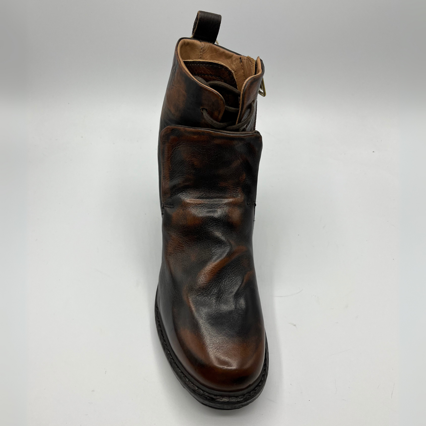 Top view of a brown and black burnished short boot with a gold accent on the heel and metallic embellishments along the shaft.