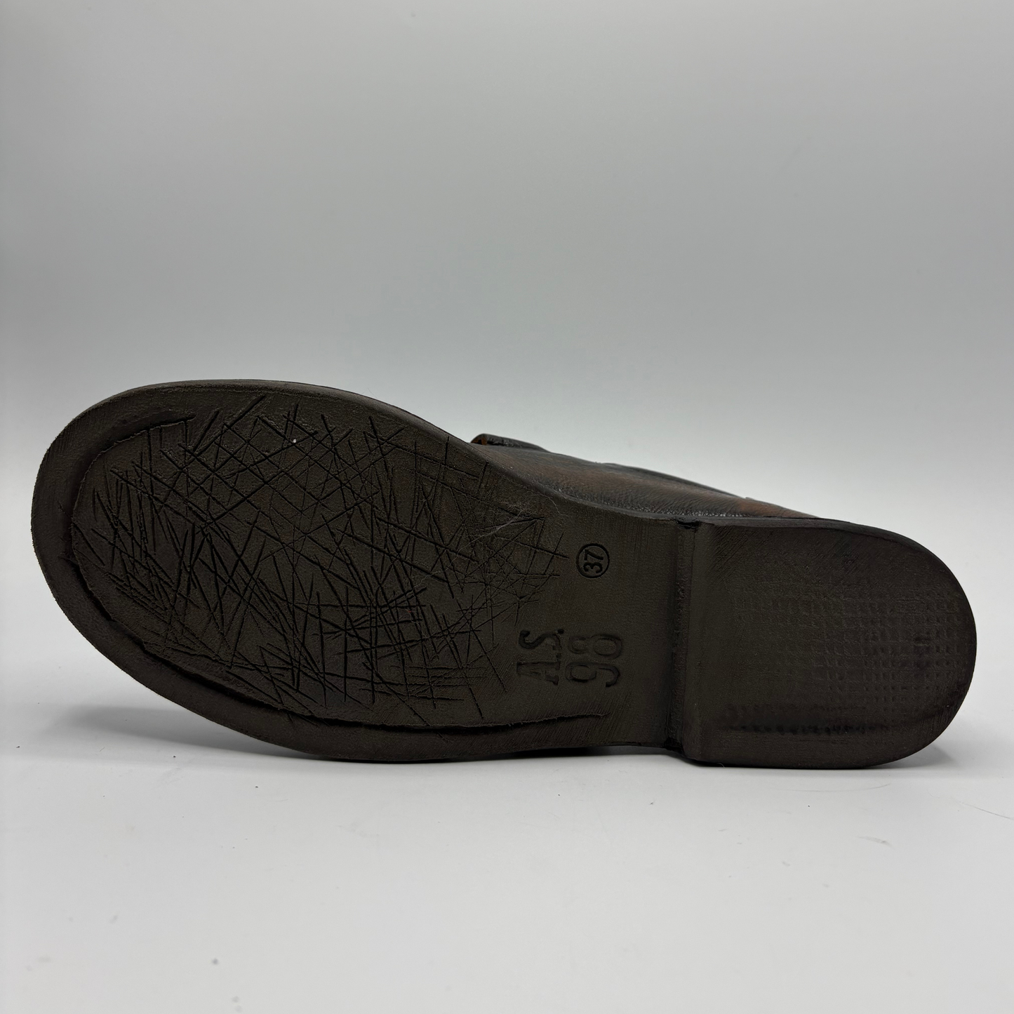 The outsole of a dark brown leather shoe, showing a textured tread pattern and embossed size markings, photographed against a neutral light gray background.