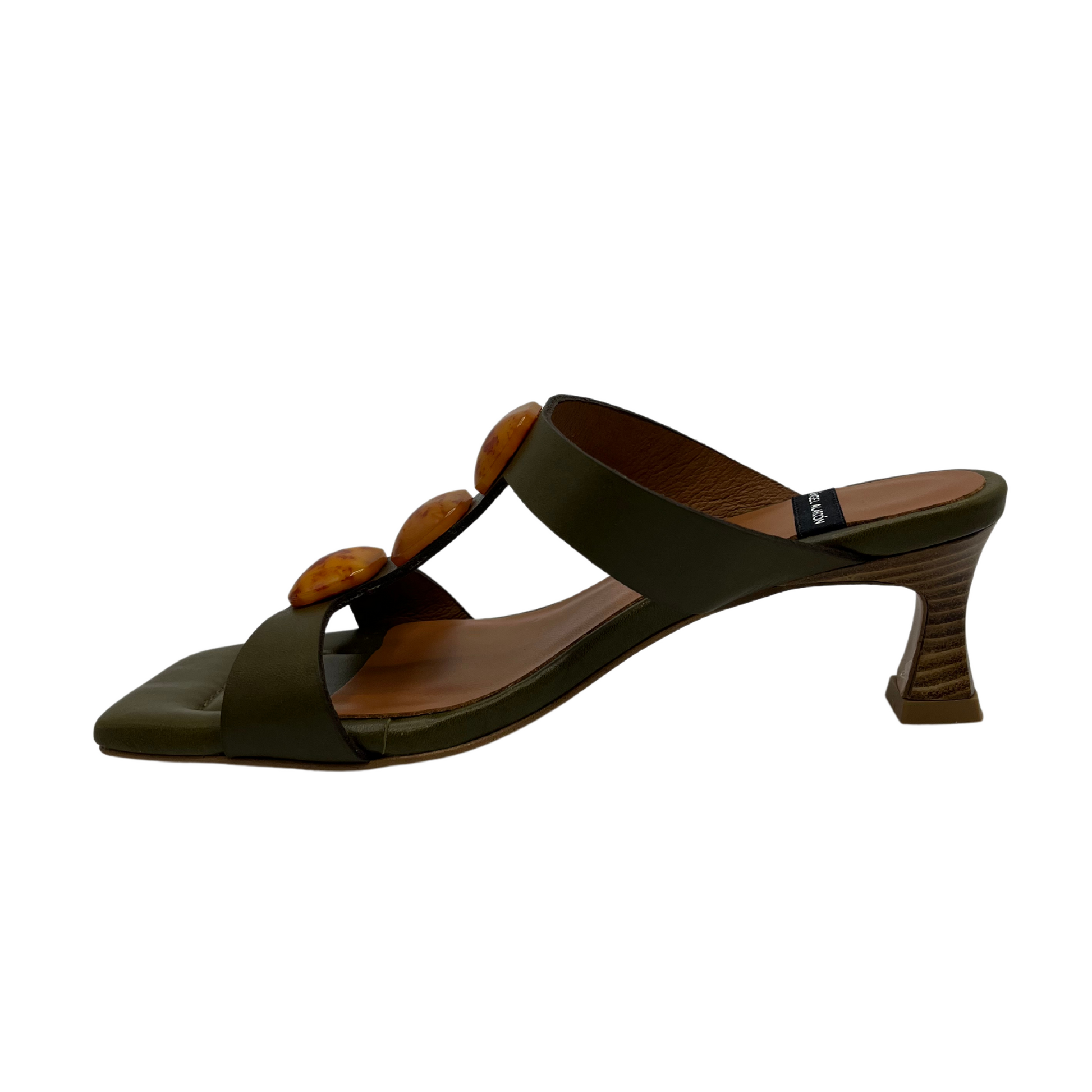 Left facing view of khaki leather sandal with square toe and square ornaments on upper. Flared heel and padded insole.