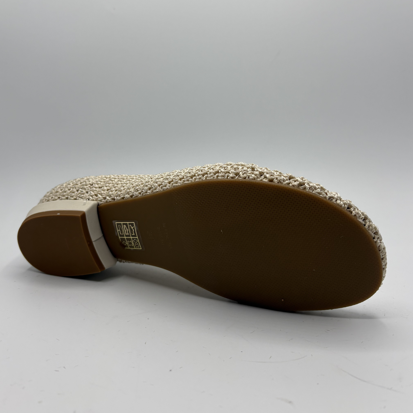 Close-up of a shoe sole with a textured pattern on a gray background