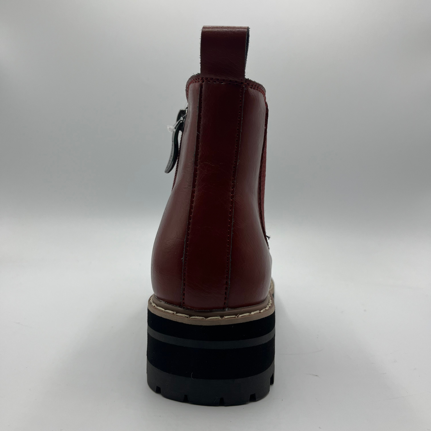 Brown leather boot with a black sole on a light gray background