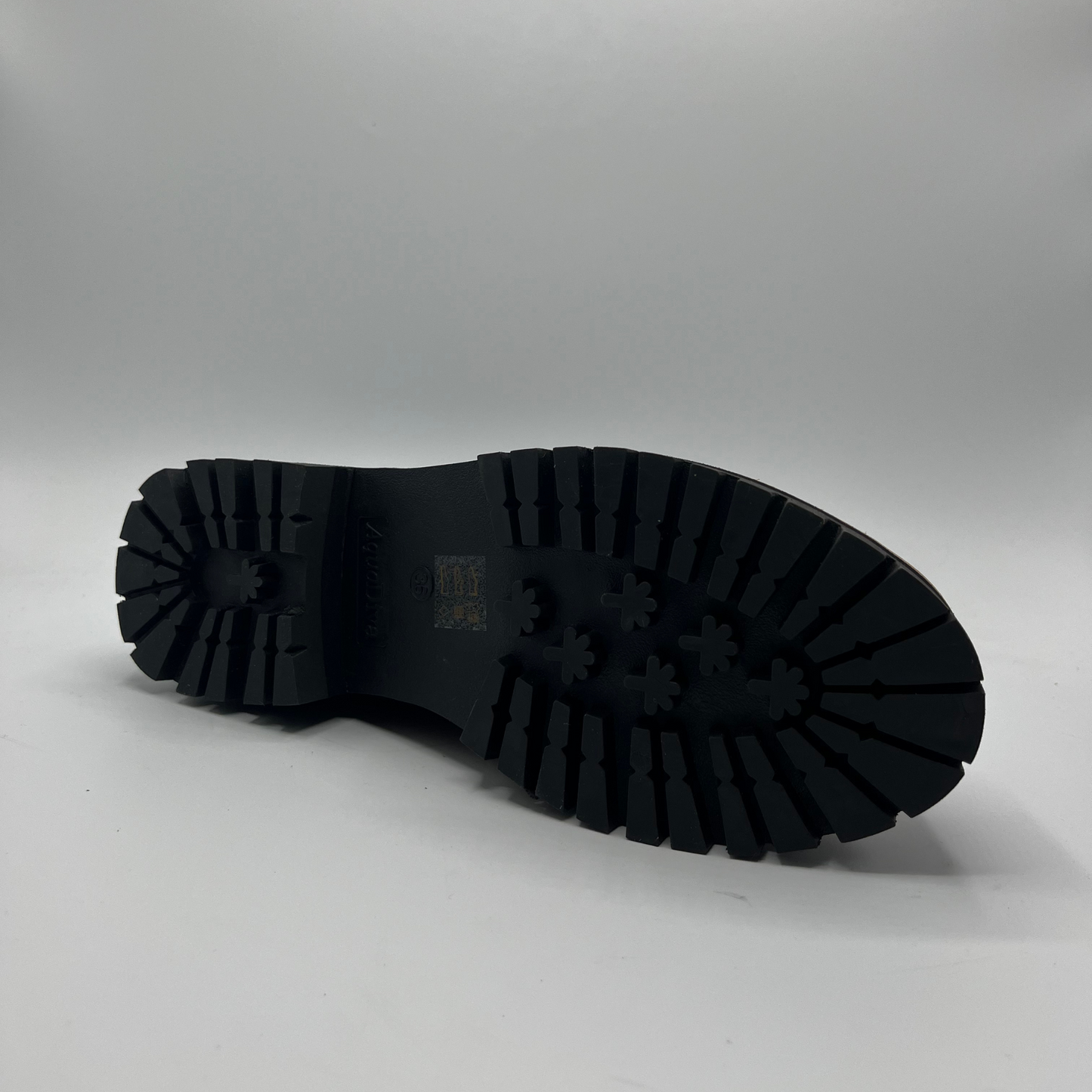 Black rubber sole of a shoe on a gray background