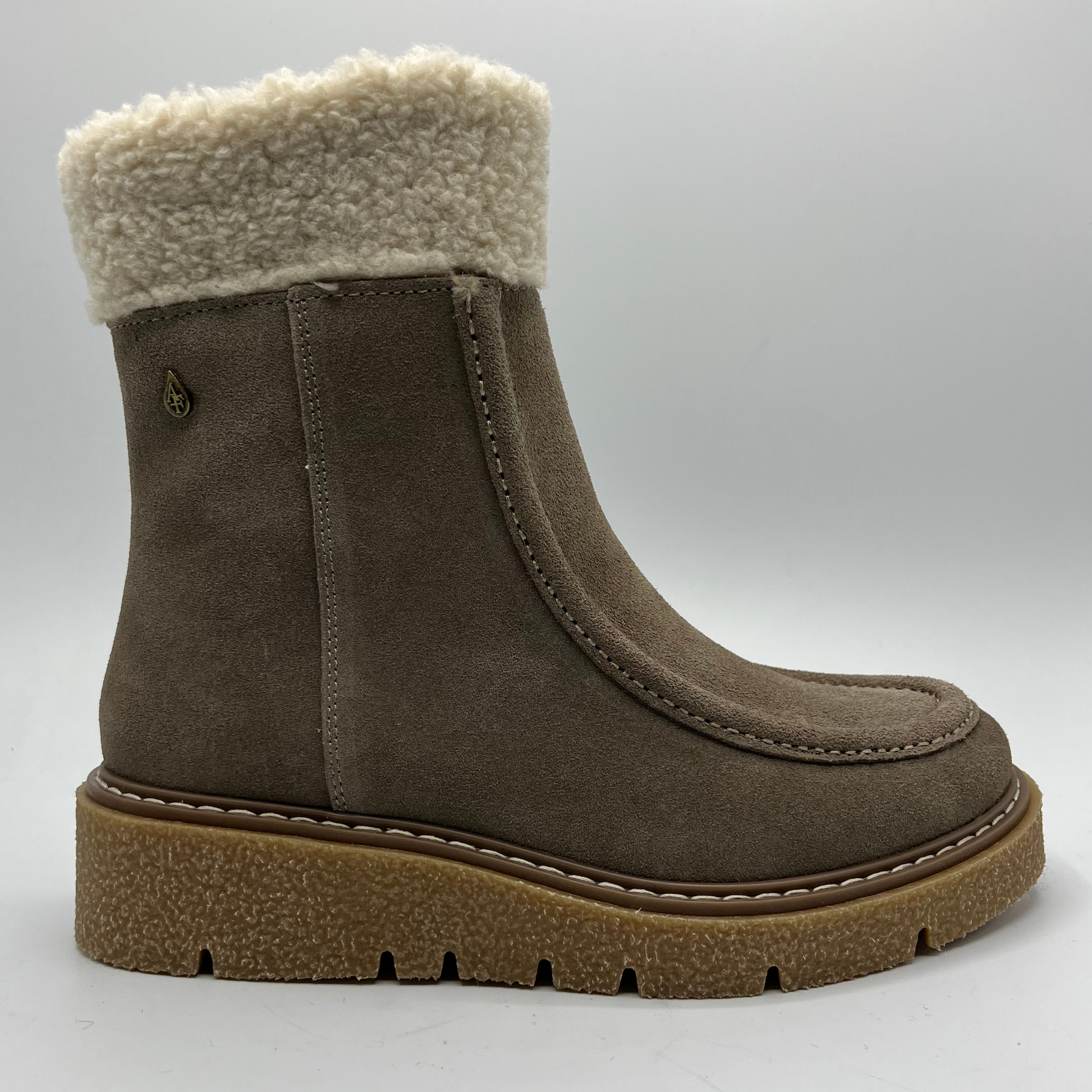 Brown suede boot with white fur lining on a light gray background