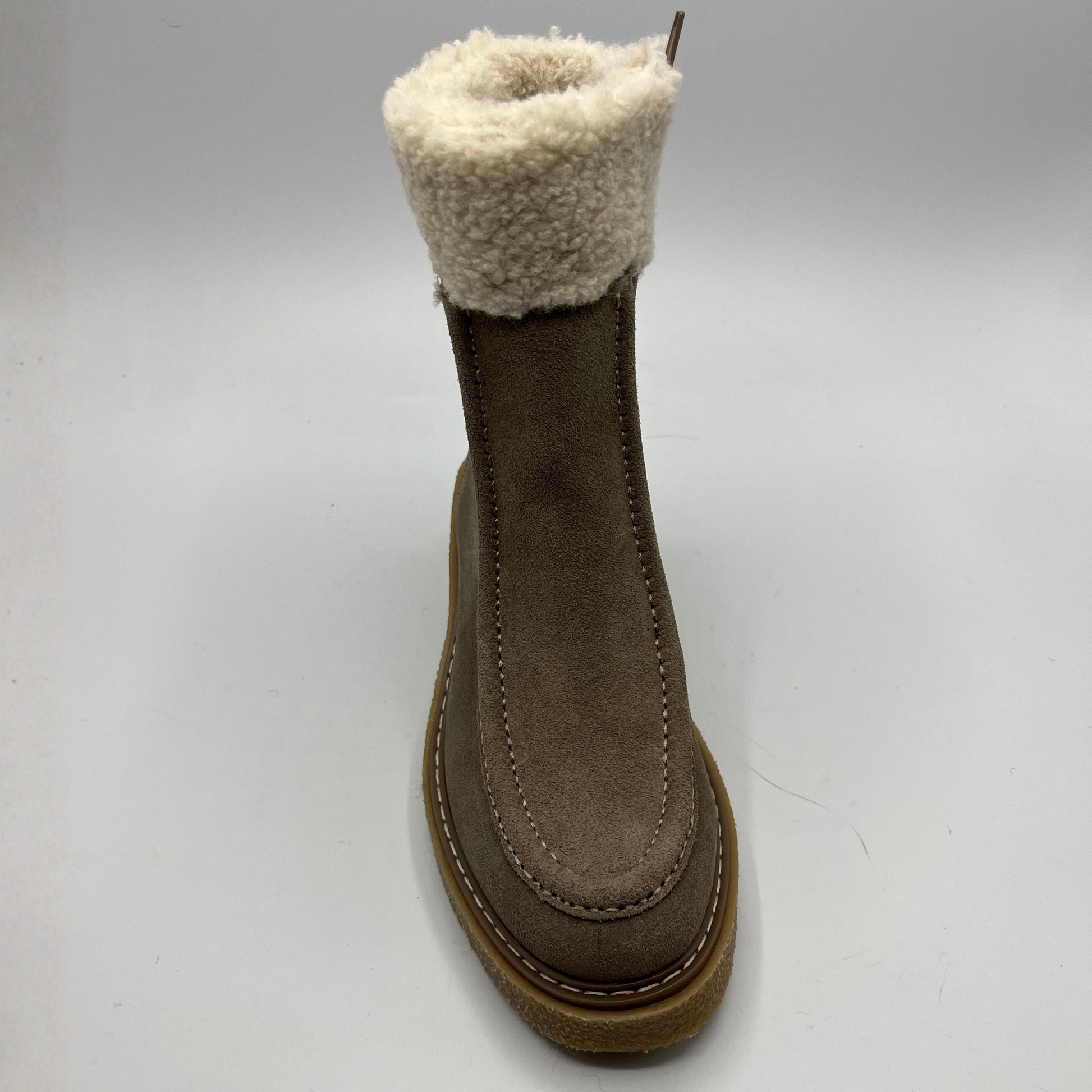 Brown boot with white fur lining on a light gray background