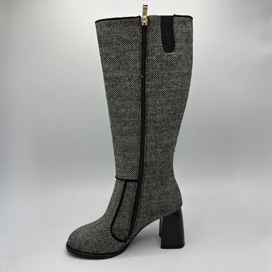 Left facing view of a tweed patterned tall boot with a side zipper and a block heel