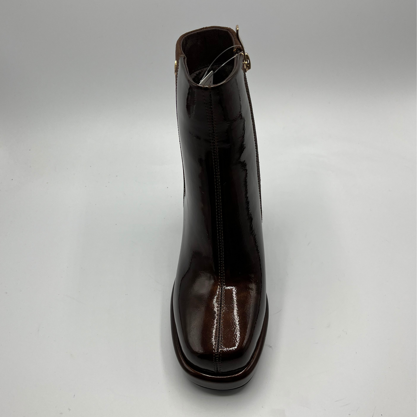 Shiny brown ankle boot on a light gray background