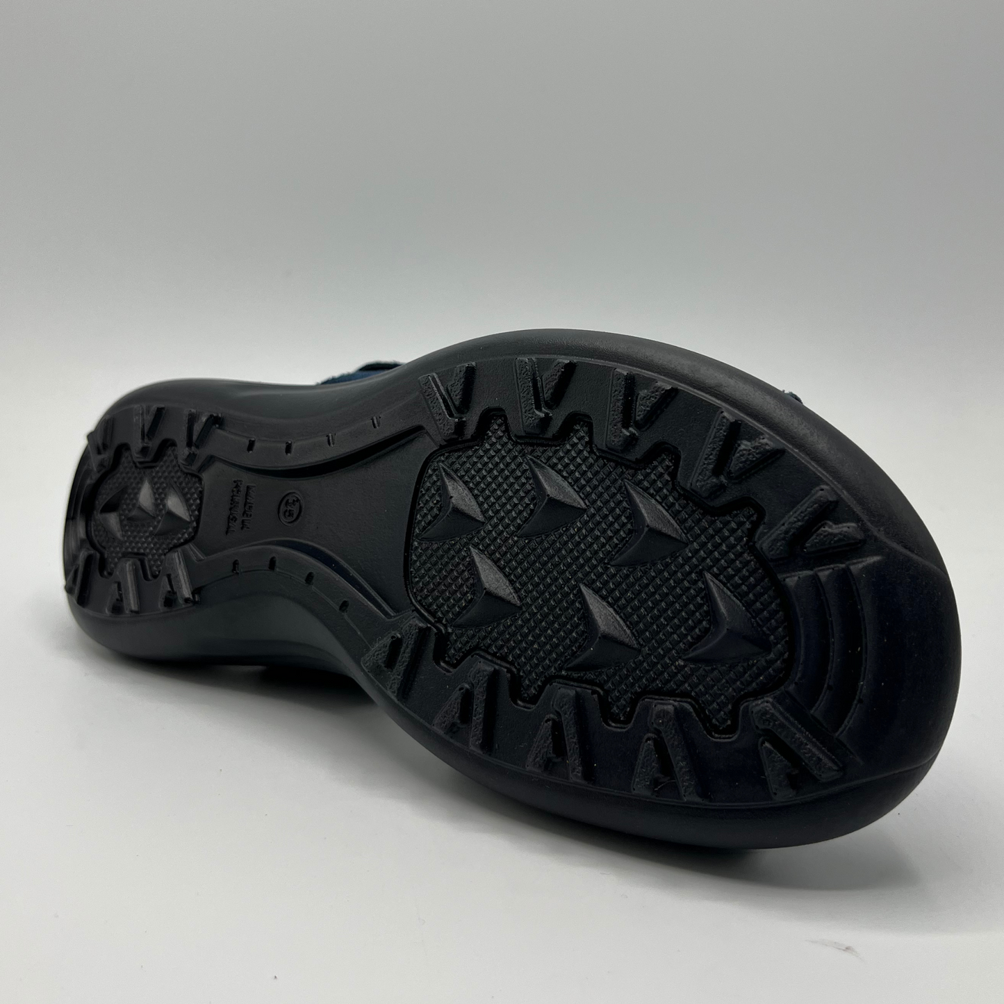Bottom view of a blue multi-strap sandal with hook and loop closures and a black supportive outsole.