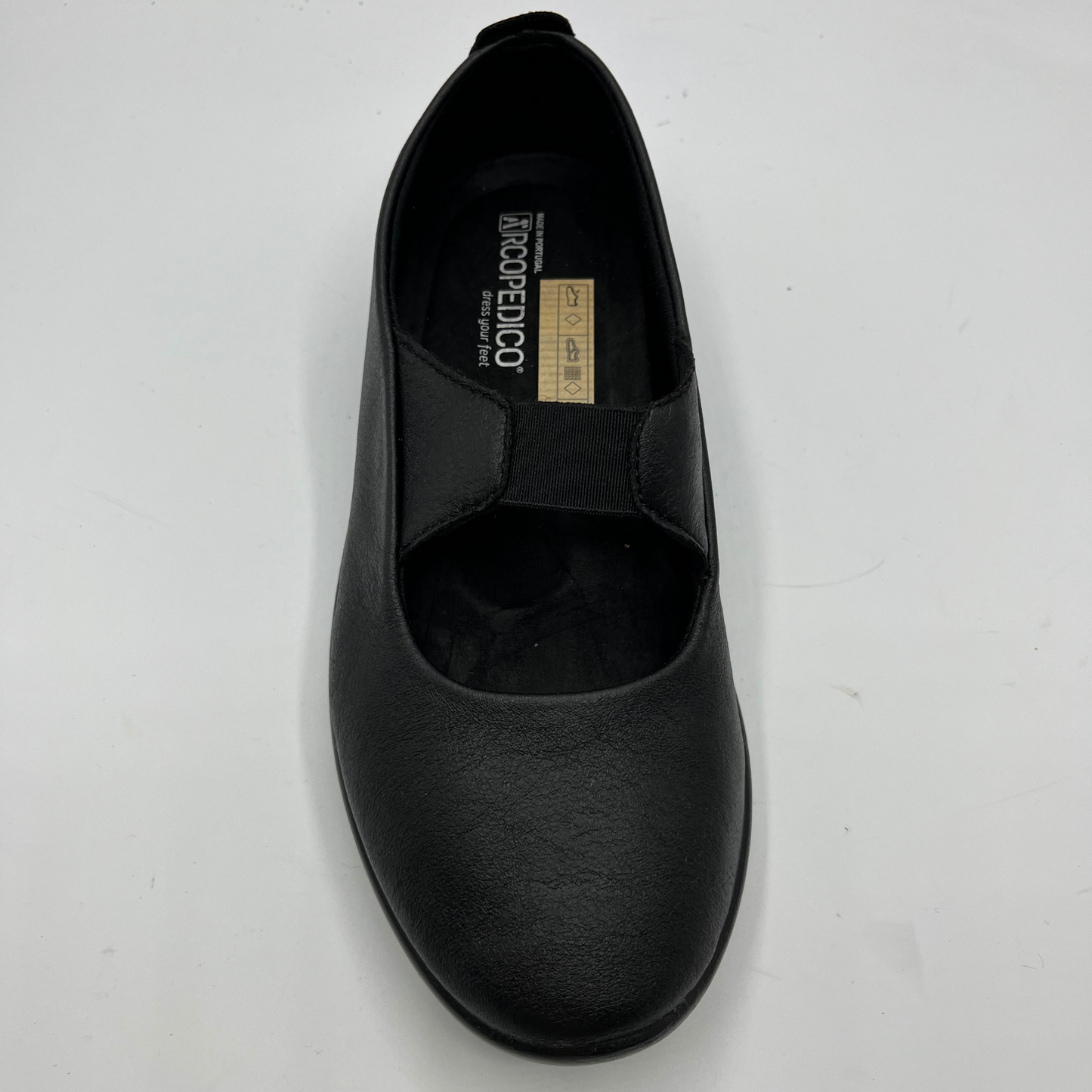Top view of a black slip on shoe with an elasticated strap