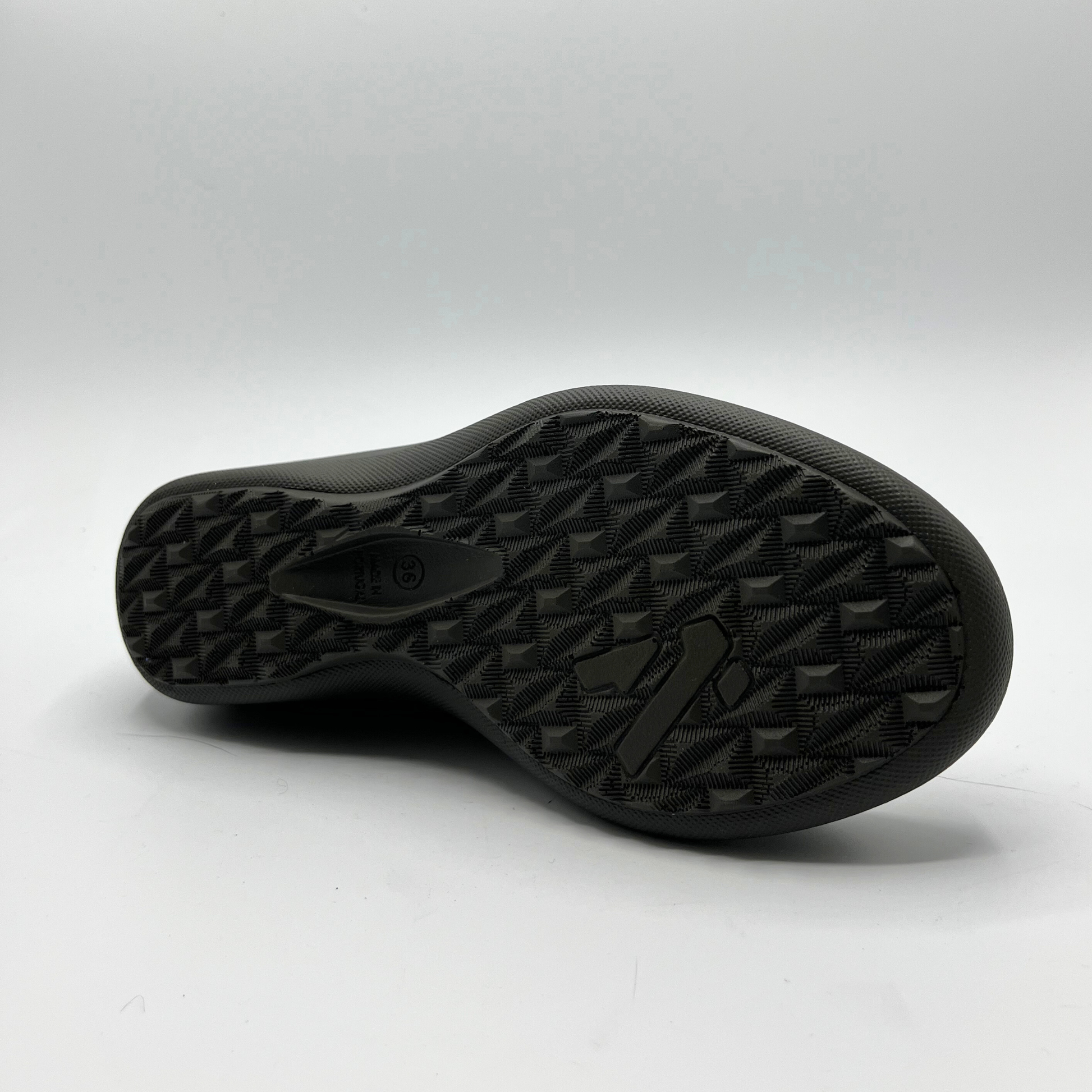 Close-up of a black shoe sole on a light gray background