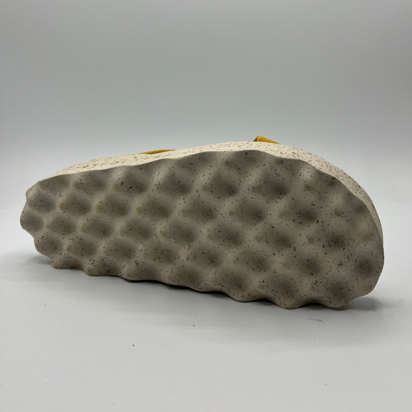 Bottom view of cushioned, cross strap sandal with a contoured footbed and white speckled outsole.