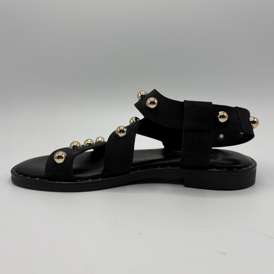 Black sandals with gold embellishments on a white background