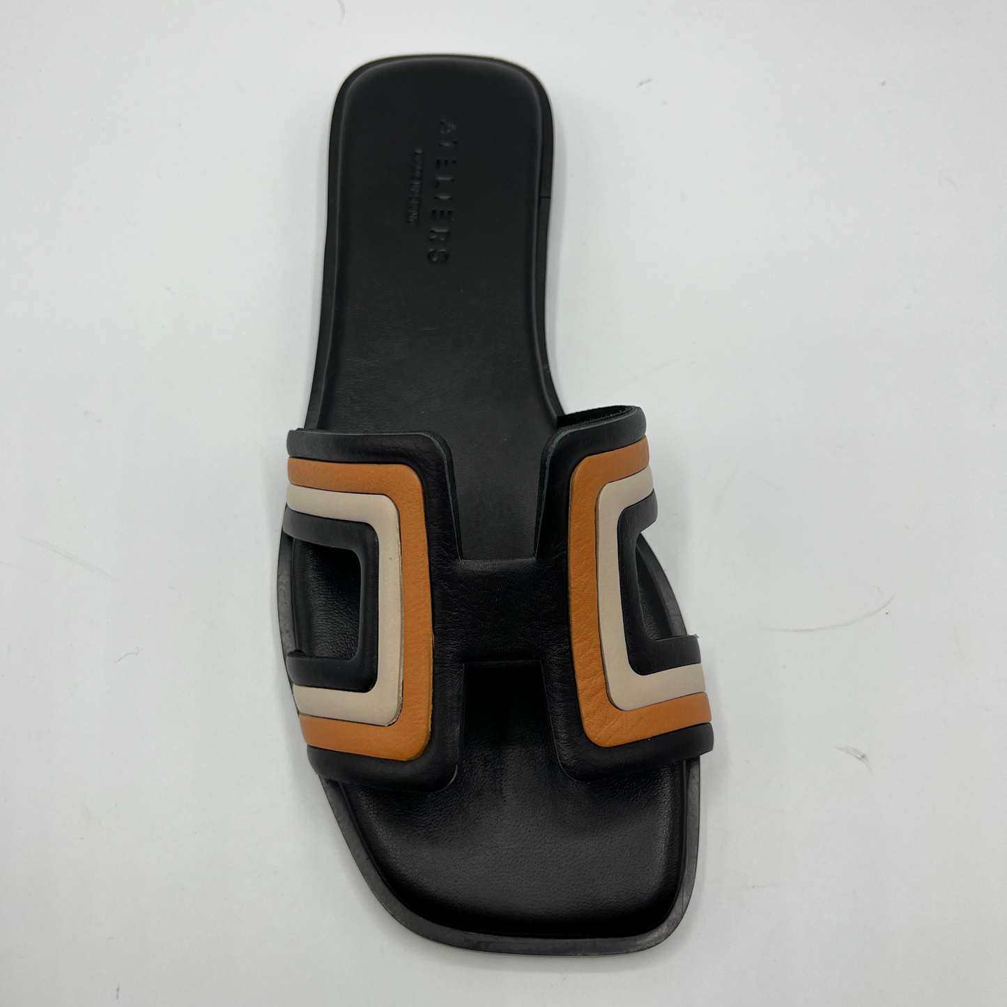 Top view of a slip on sandal with a black, brown and cream "H" strap and a black leather wrapped footbed.