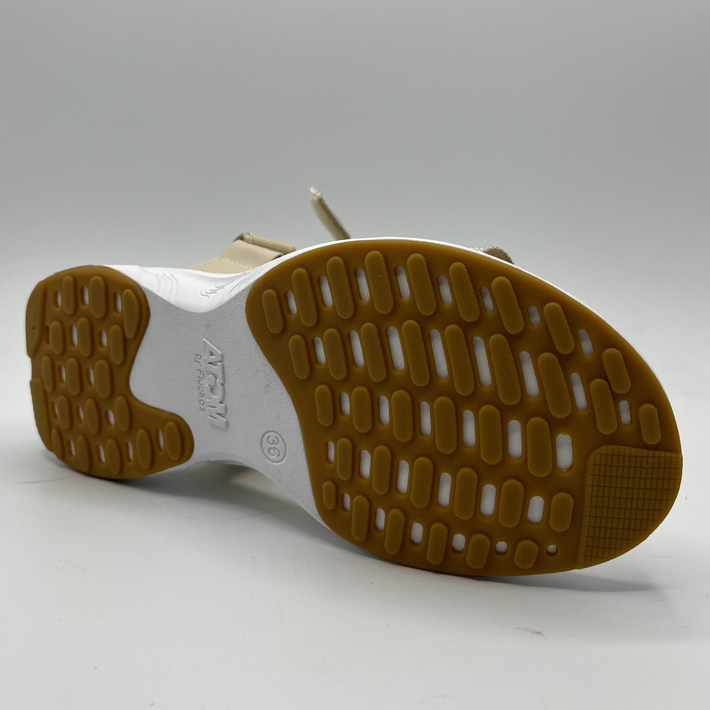 Bottom view of a sand coloured sandal with adjustable velcro straps and a contoured, lightweight footbed.
