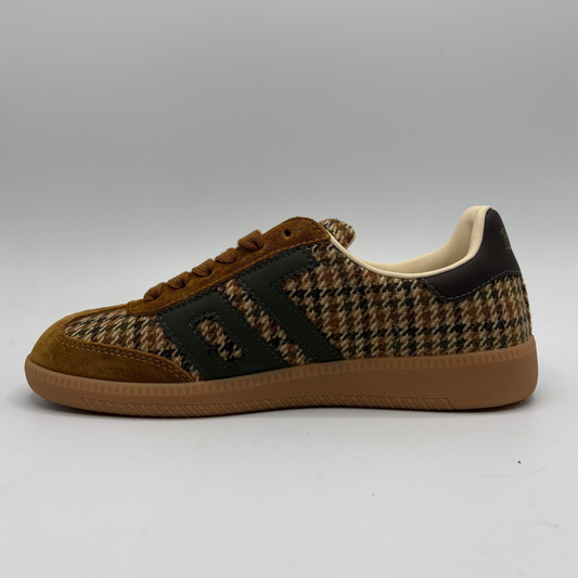 A low-top sneaker featuring a brown and beige houndstooth pattern on the upper, brown suede overlays, a black side stripe detail, and a brown gum sole, shown against a neutral gray background.