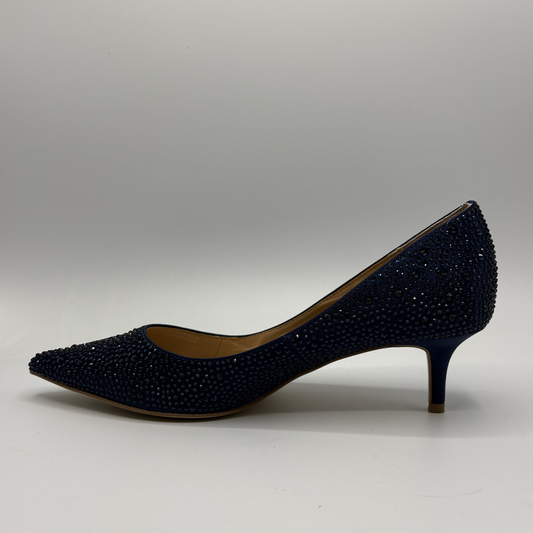 Navy blue studded high heel shoe on a gray background