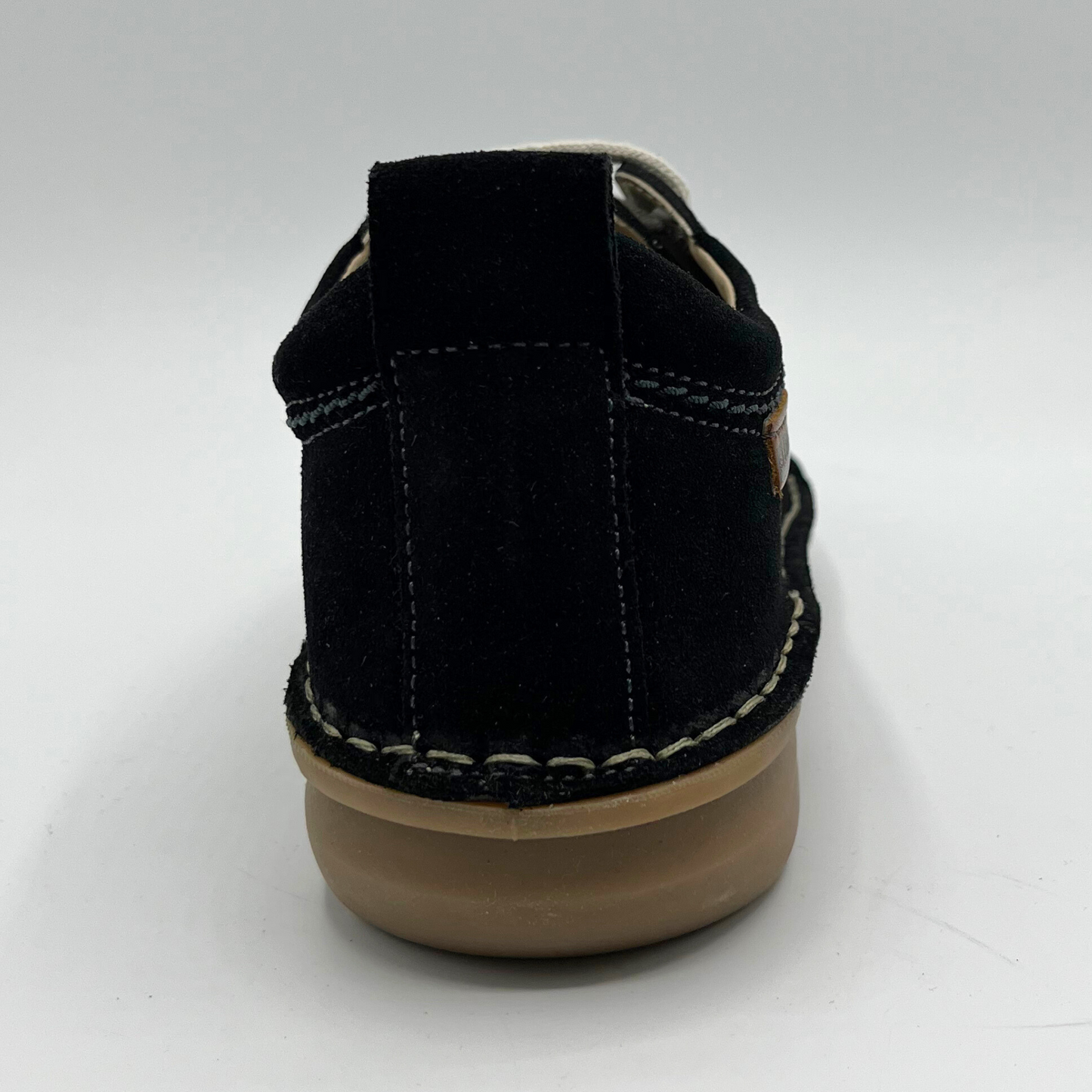 Black shoe with brown sole on a white background