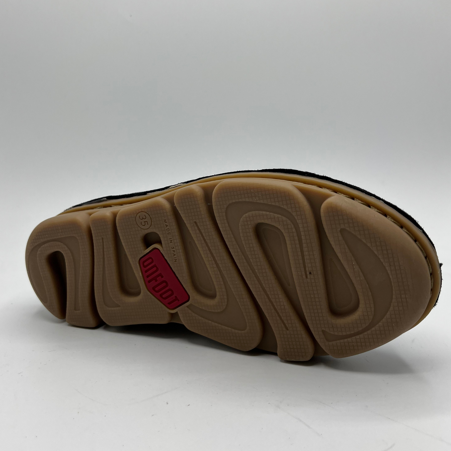 Close-up of a shoe sole with a red label on a white background