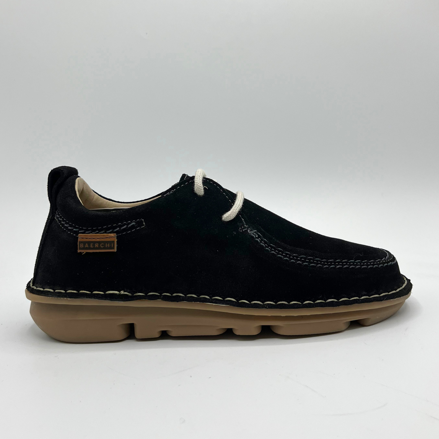 Black shoe with tan sole on a white background