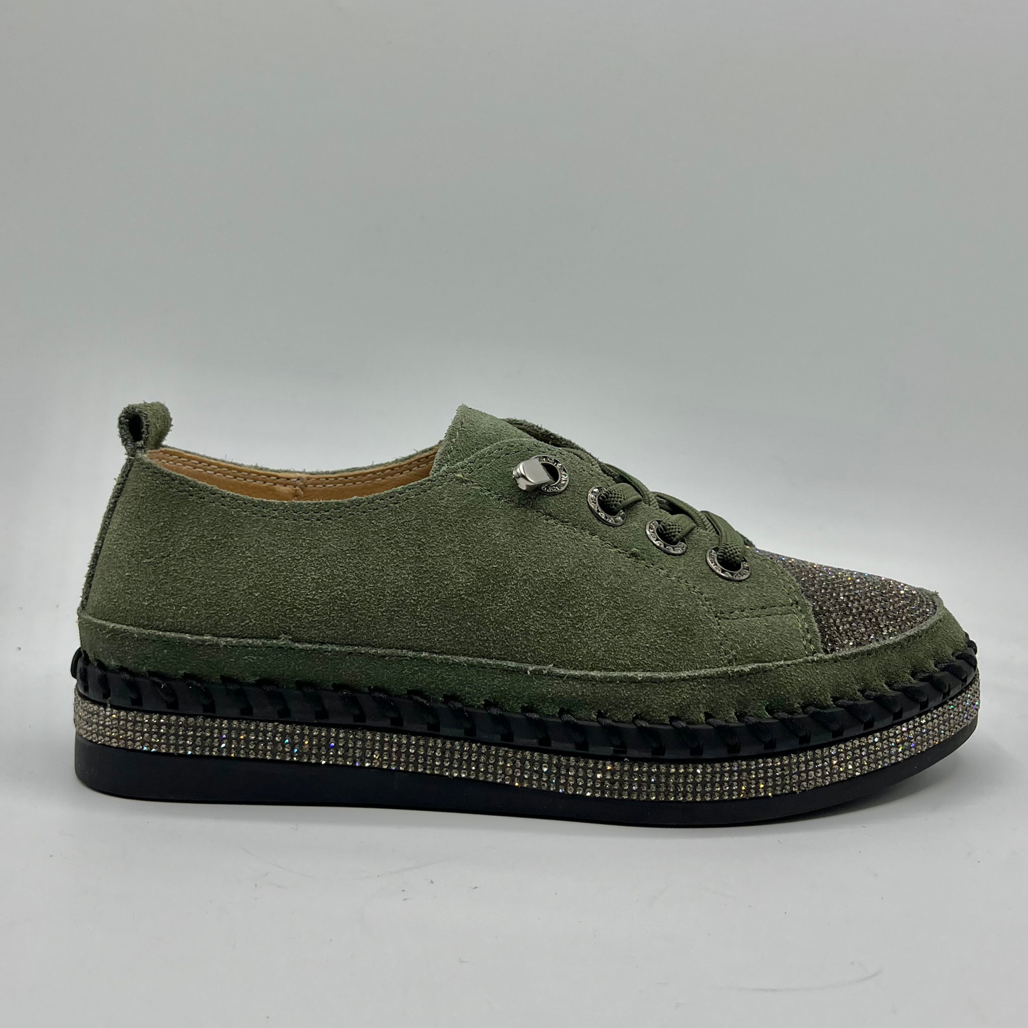 Green sneaker with embellished sole on a gray background