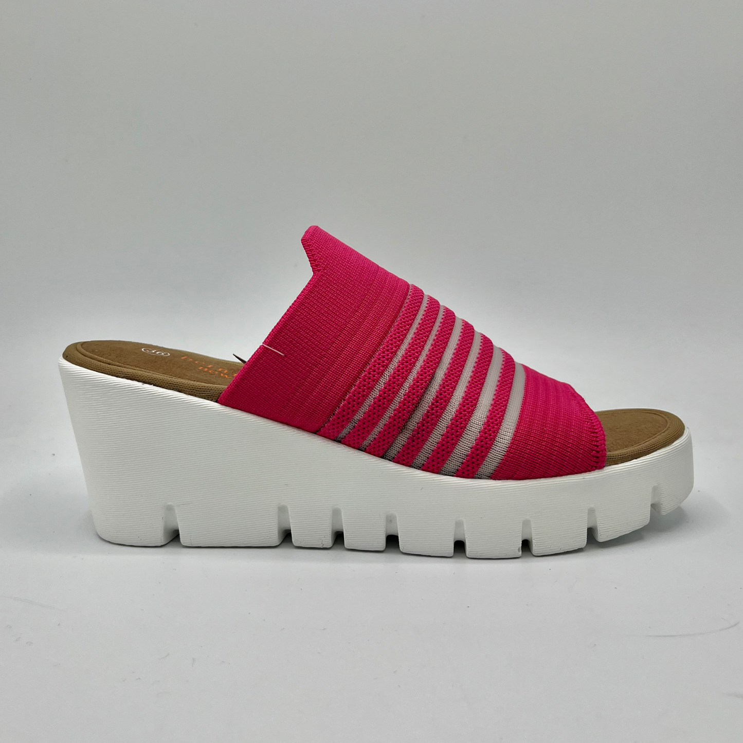 Right facing view of a fuschia elastic slip on sandal with a white wedge heel.