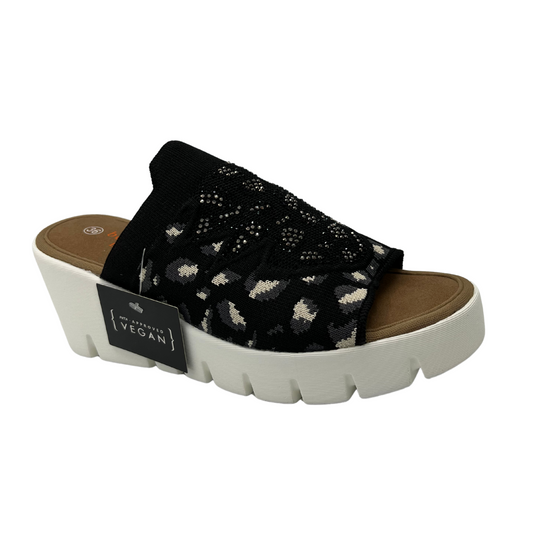 Angled view of a slip on wedge heel. White rubber outsole and stretchy knit upper.