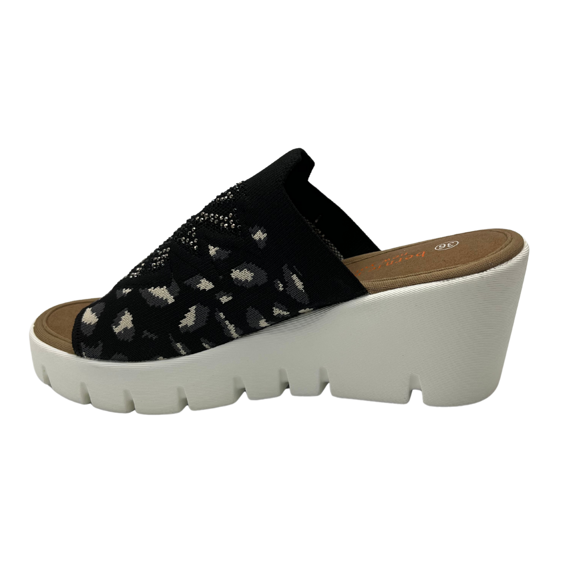 Left facing view of a slip on wedge heel. White rubber outsole and stretchy knit upper.