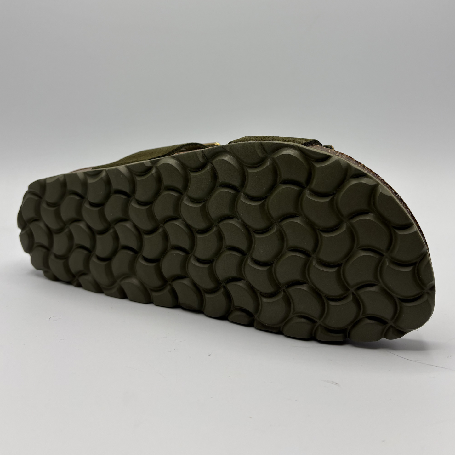 Olive green sandal with textured sole on a white background