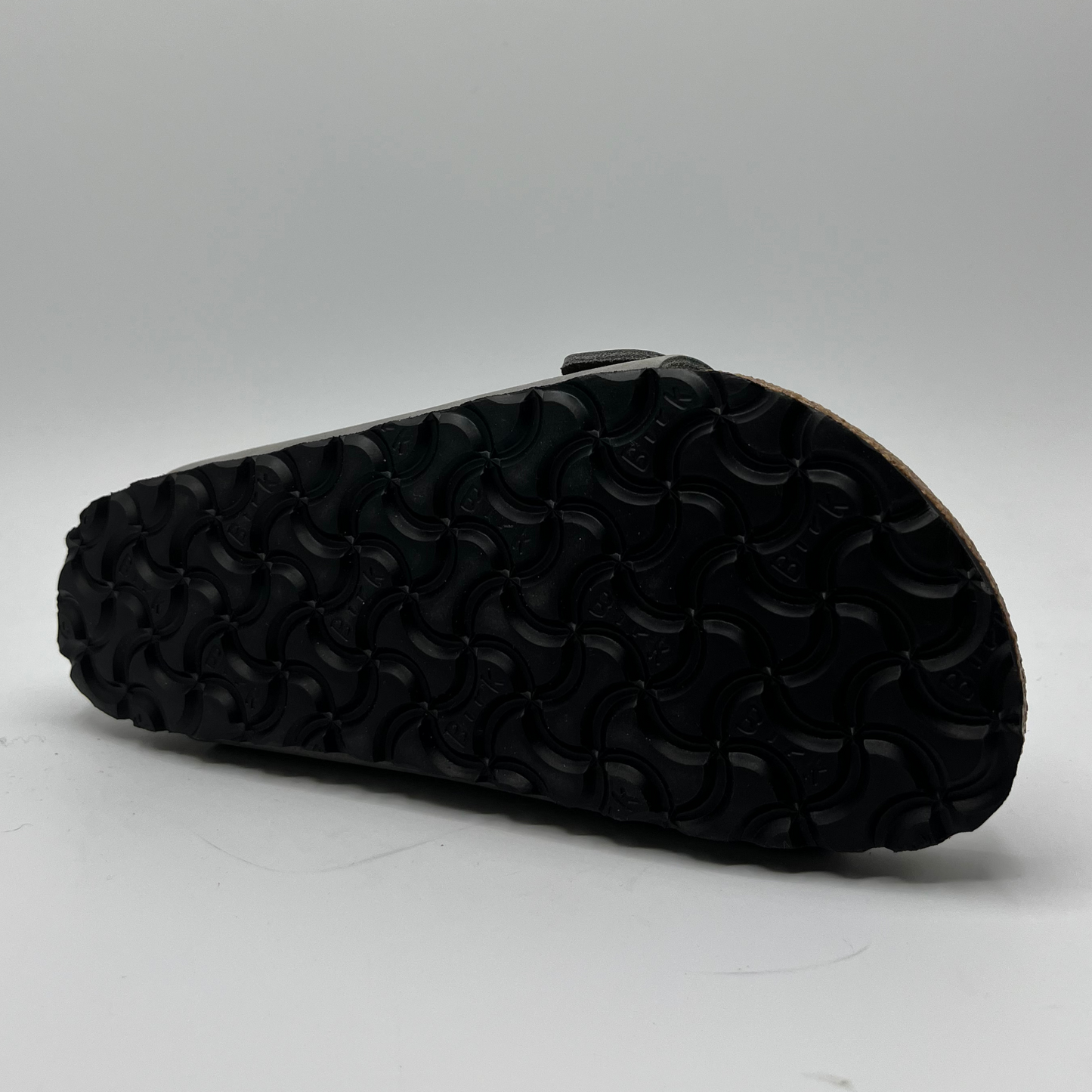 Bottom view of a leather sandal with a contoured cork footbed and two adjustable straps.