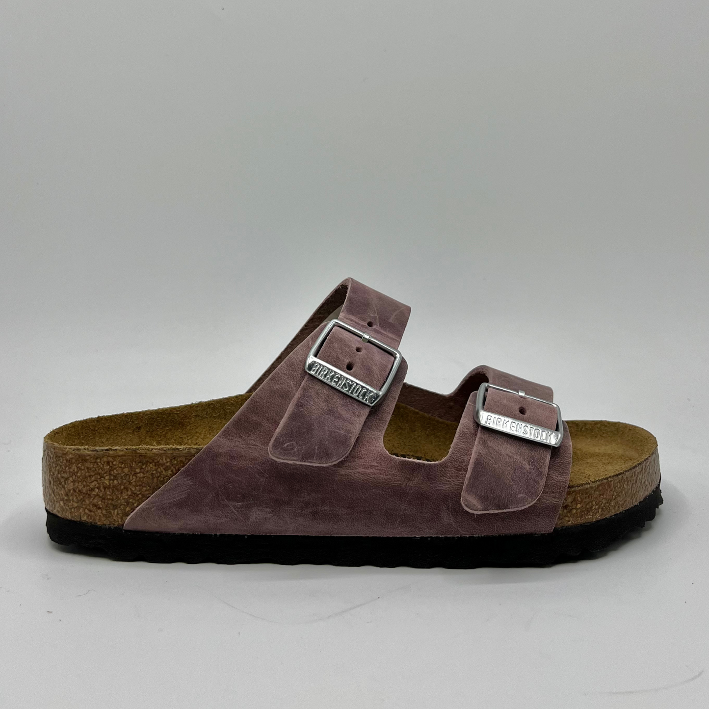 Right facing view of a lavender oiled leather sandal with a contoured cork footbed and two adjustable straps.