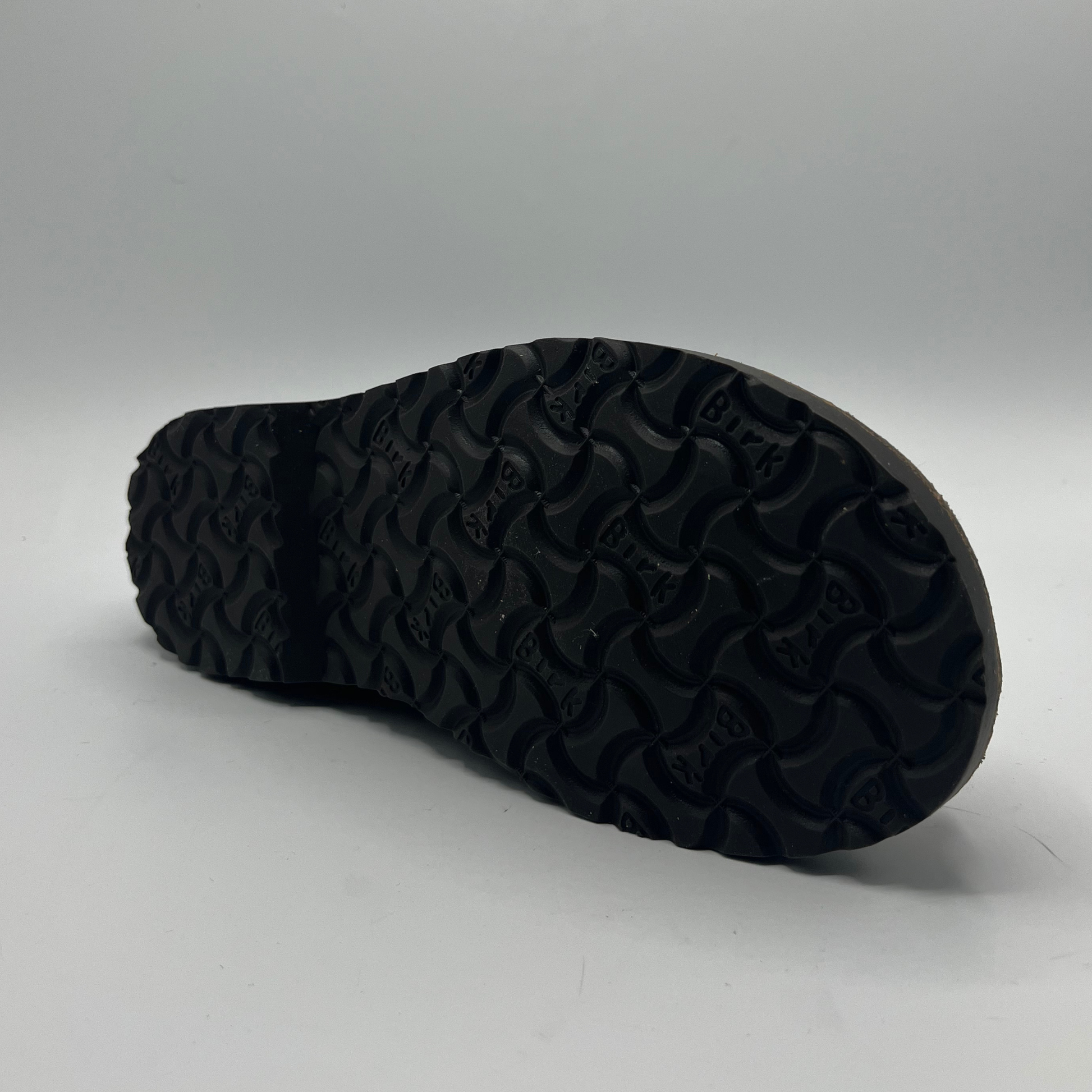 Black sole of a shoe on a gray background