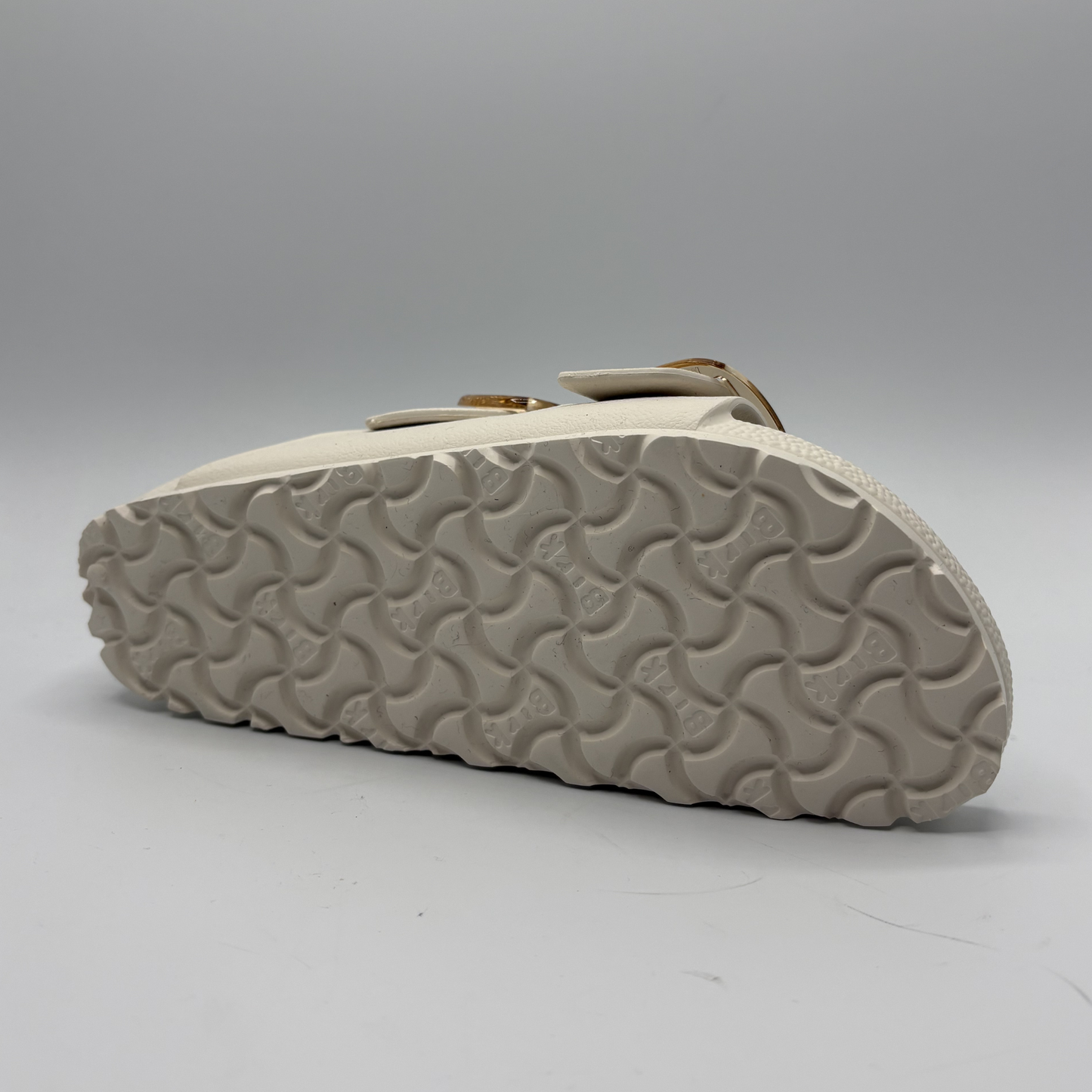 Eggshell sandal sole with wavy pattern on a gray background