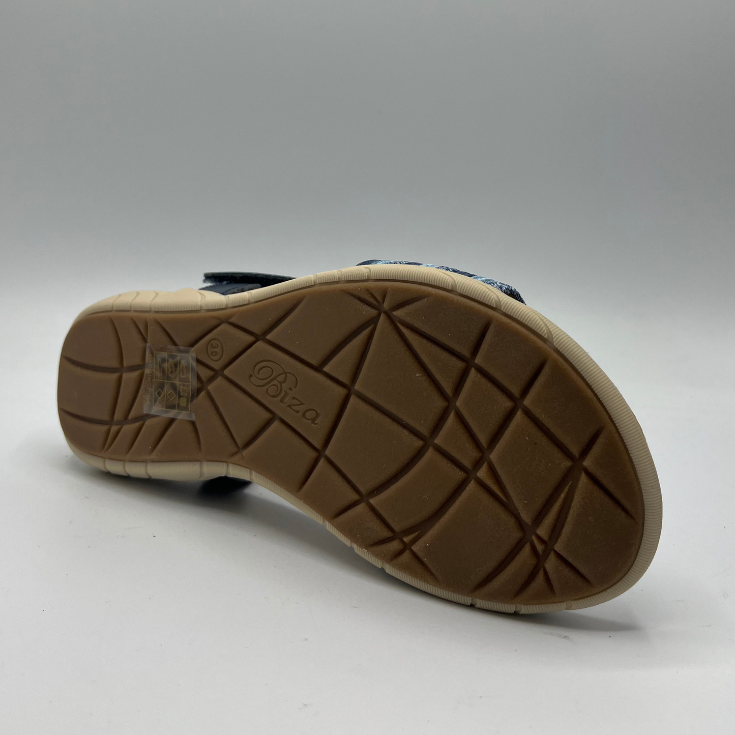 Bottom view of a navy leather and elastic strapped sandal with a cushioned, contoured footbed and lightweight rubber outsole.