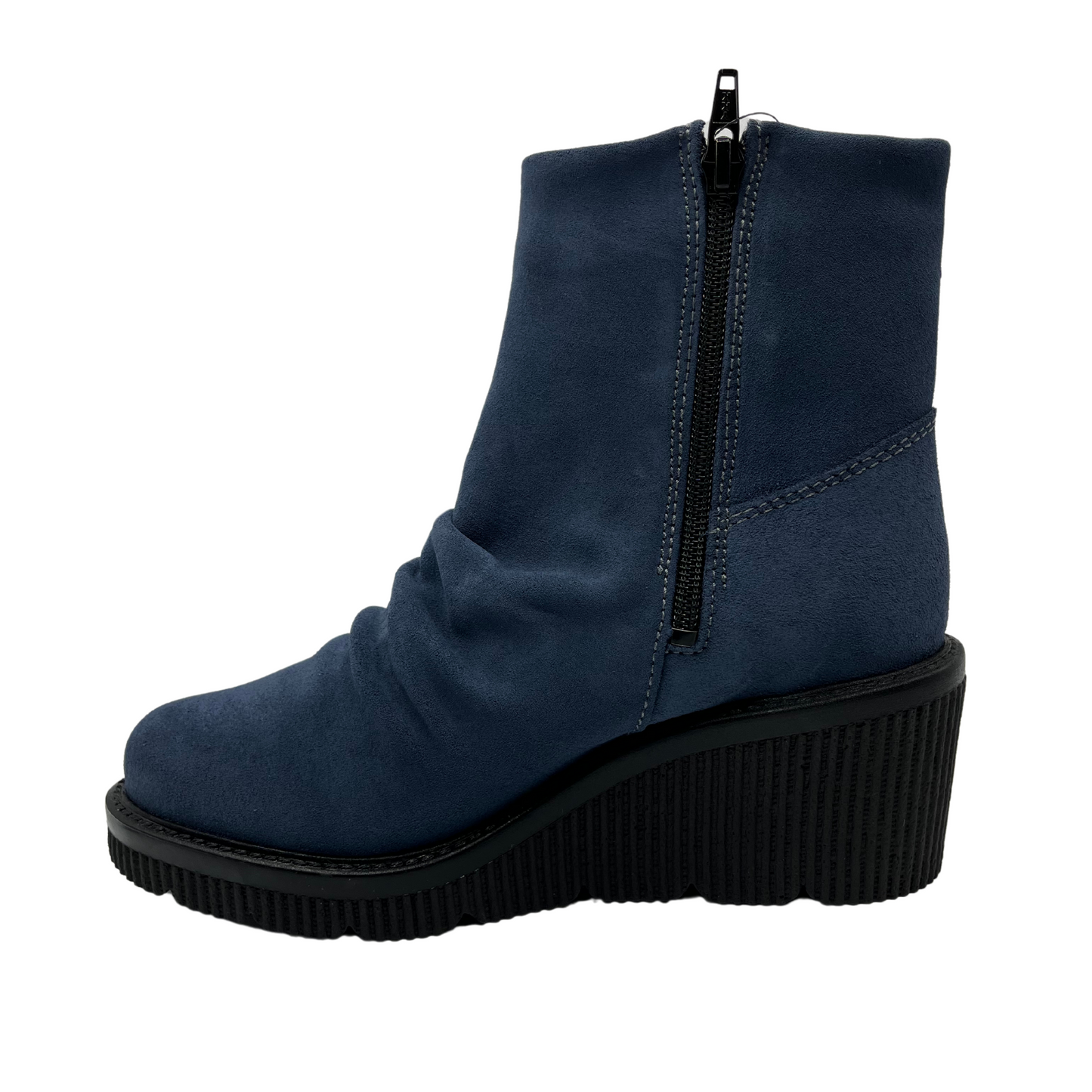 Left facing view of denim blue short bootie with slouched front, side zipper closure and black wedge heel.