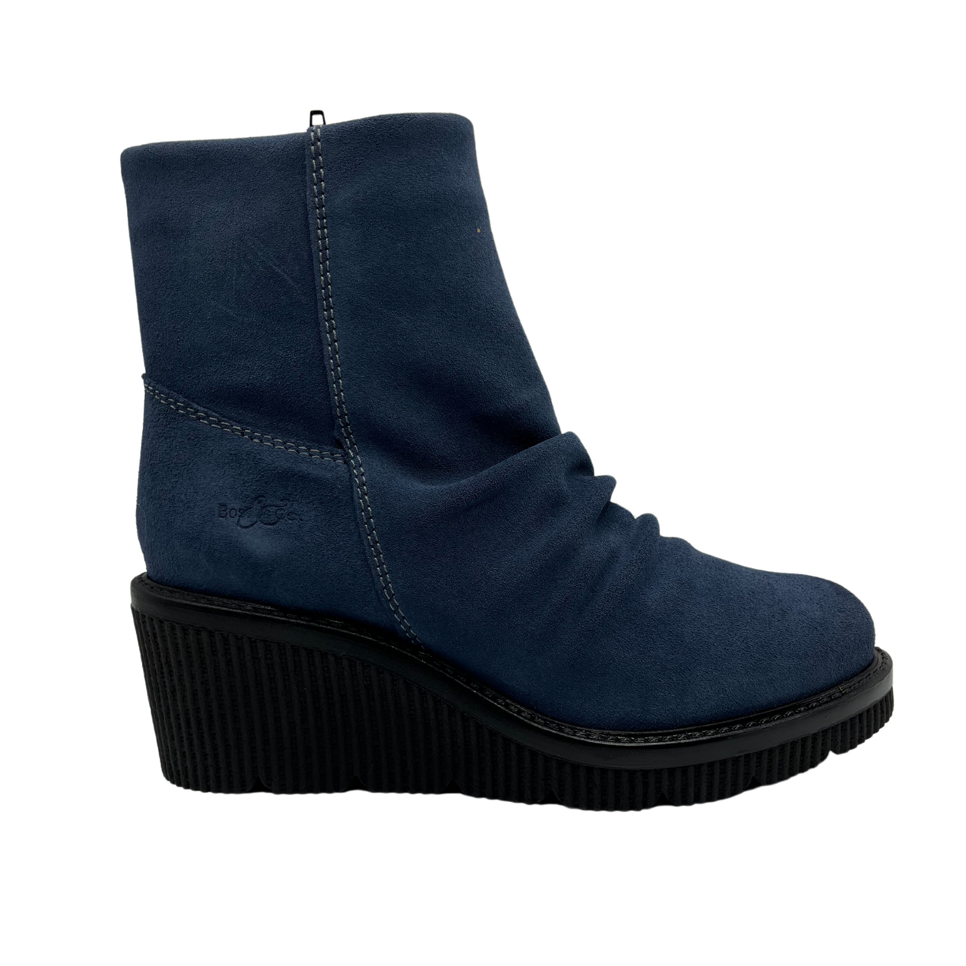 Right facing view of denim blue short bootie with slouched front, side zipper closure and black wedge heel.