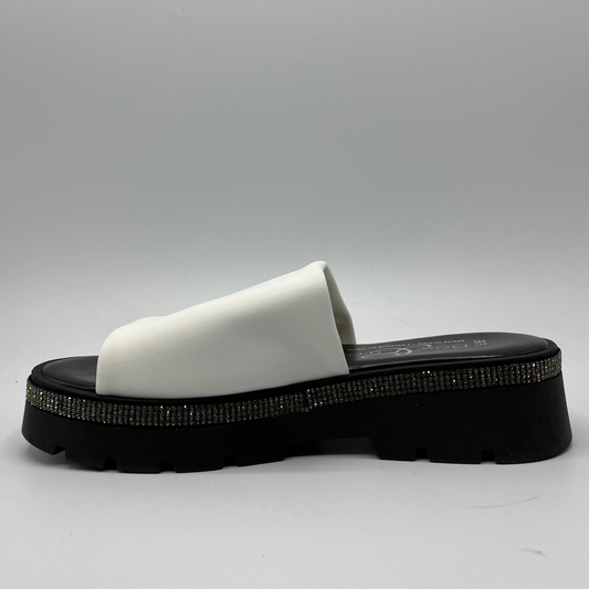 Left facing view of a black and white sandal with a white leather upper and a rhinestone wrap detail around the upper.