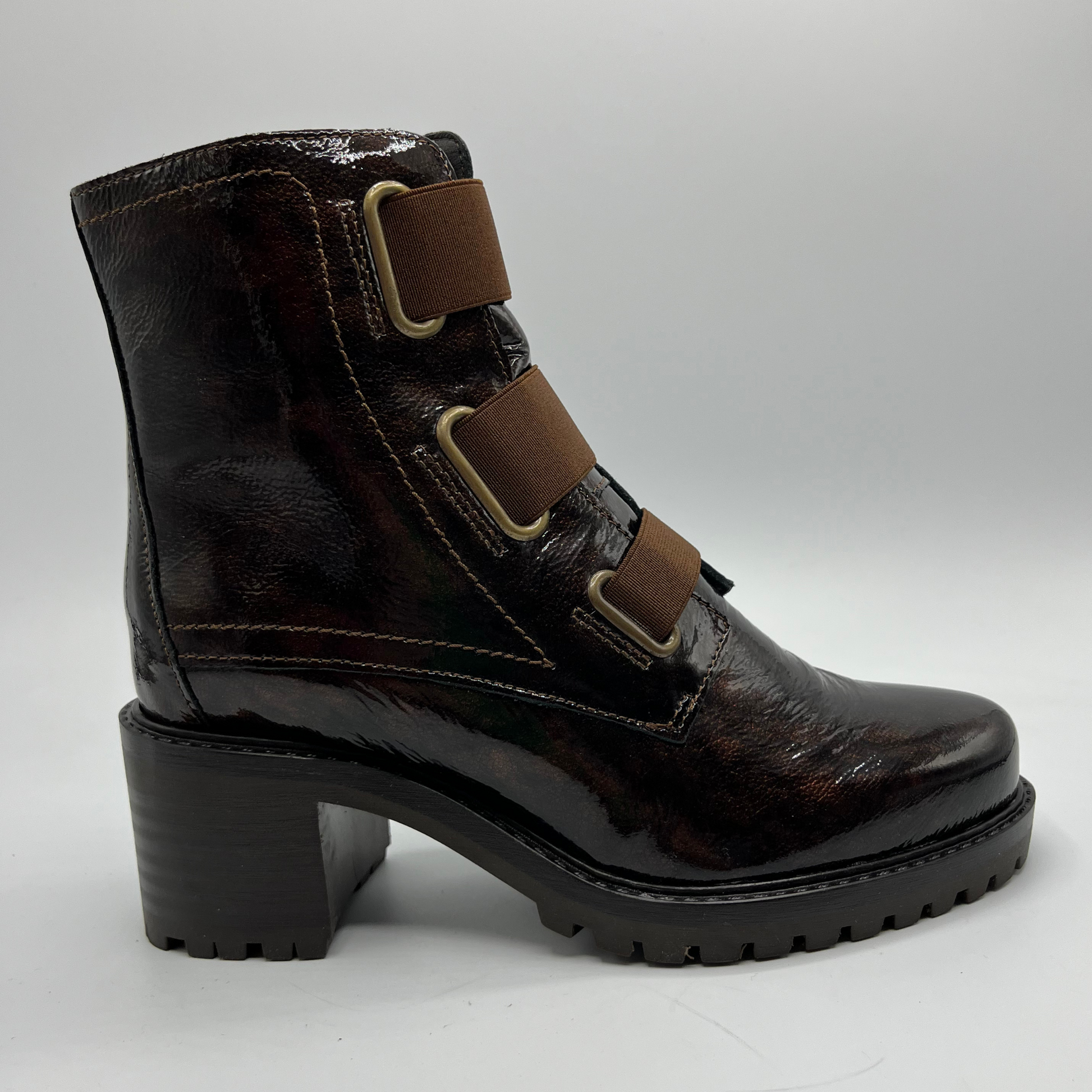 Brown leather boot with multiple straps on a light gray background