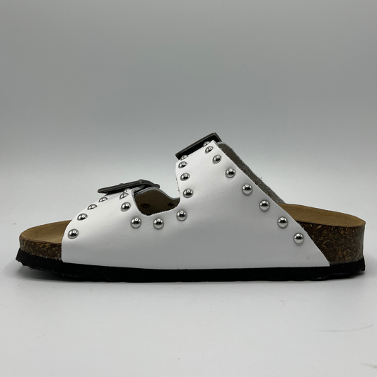 Left view of a white leather sandal with a contoured cork footbed. Featuring adjustable buckle straps and silver stud details.