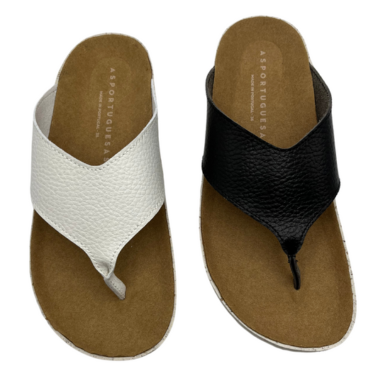 Top view of two thong sandals, one is white and one is black. Both have brown faux suede covered footbeds and white outsoles