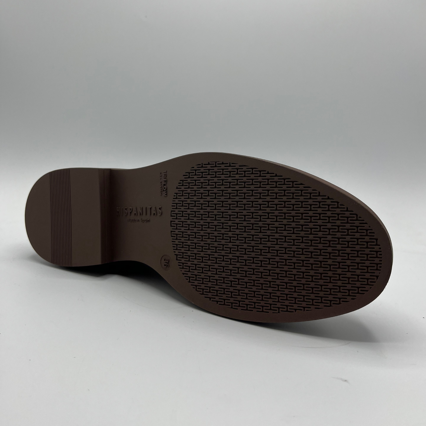 Brown shoe sole with brand logo on a gray background