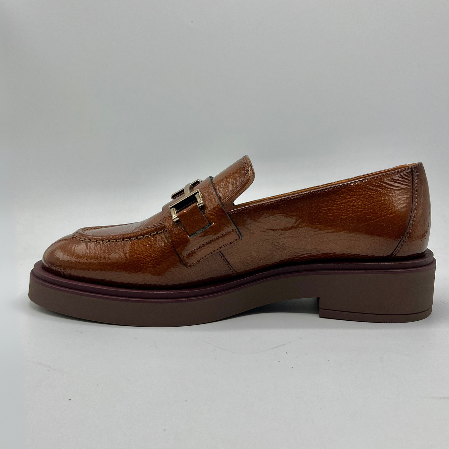 Brown leather loafer shoe on a light gray background