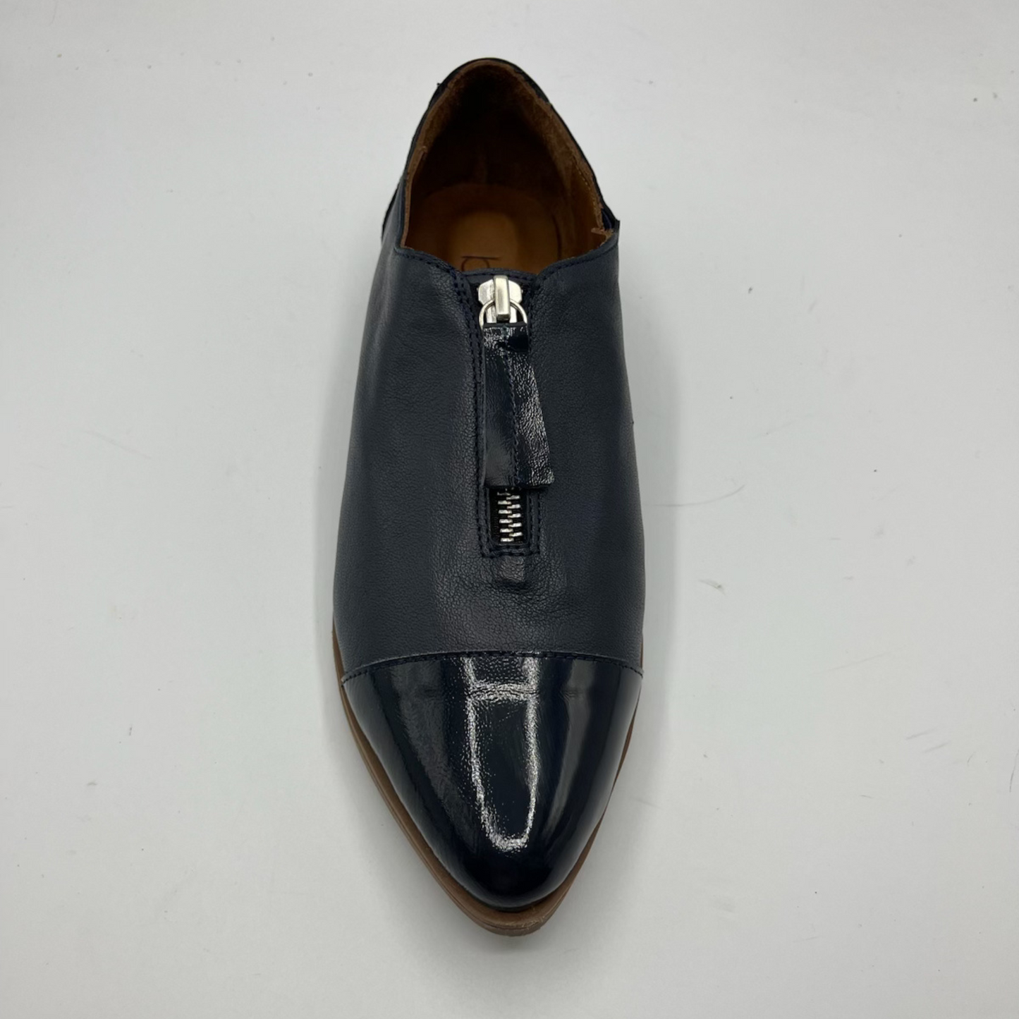 Navy leather shoe with a zipper on a light gray background