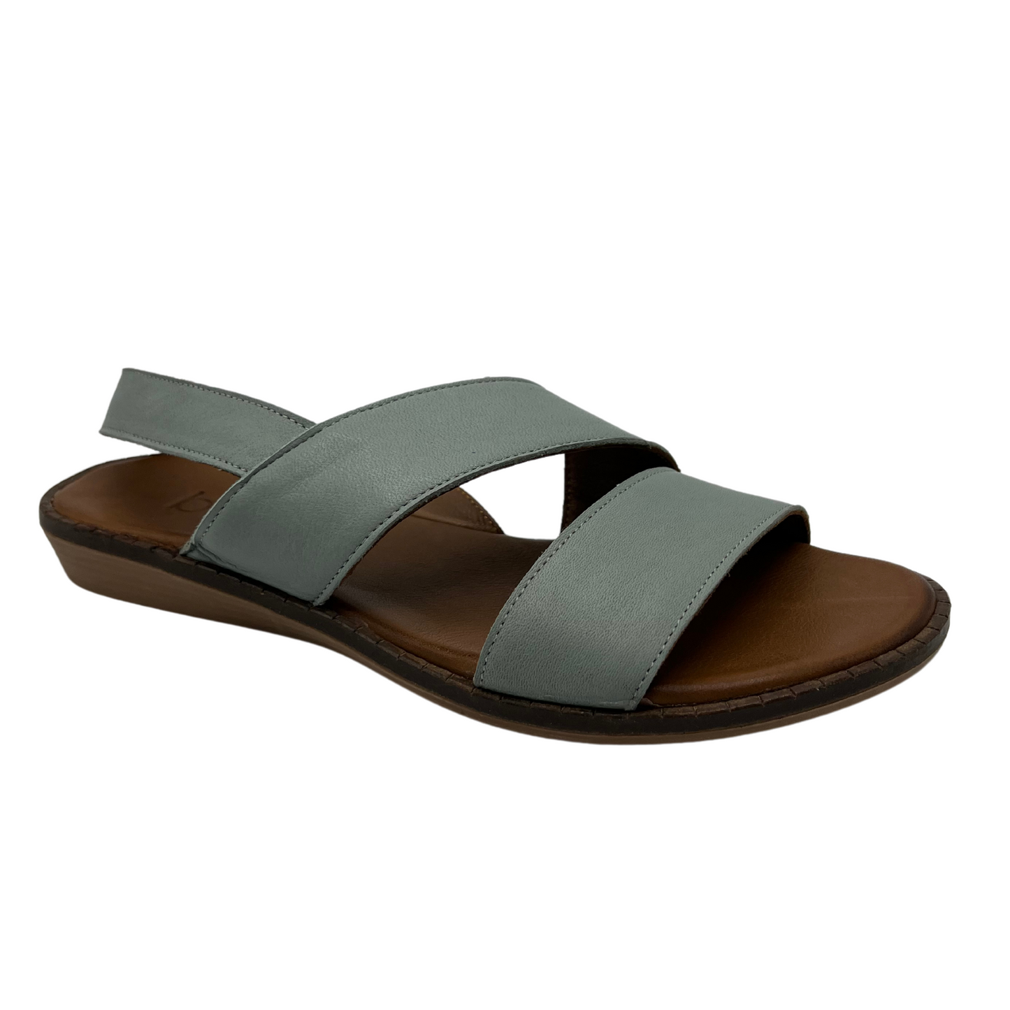 45 degree angled view of pale green leather sandal with slingback strap and low wedge heel