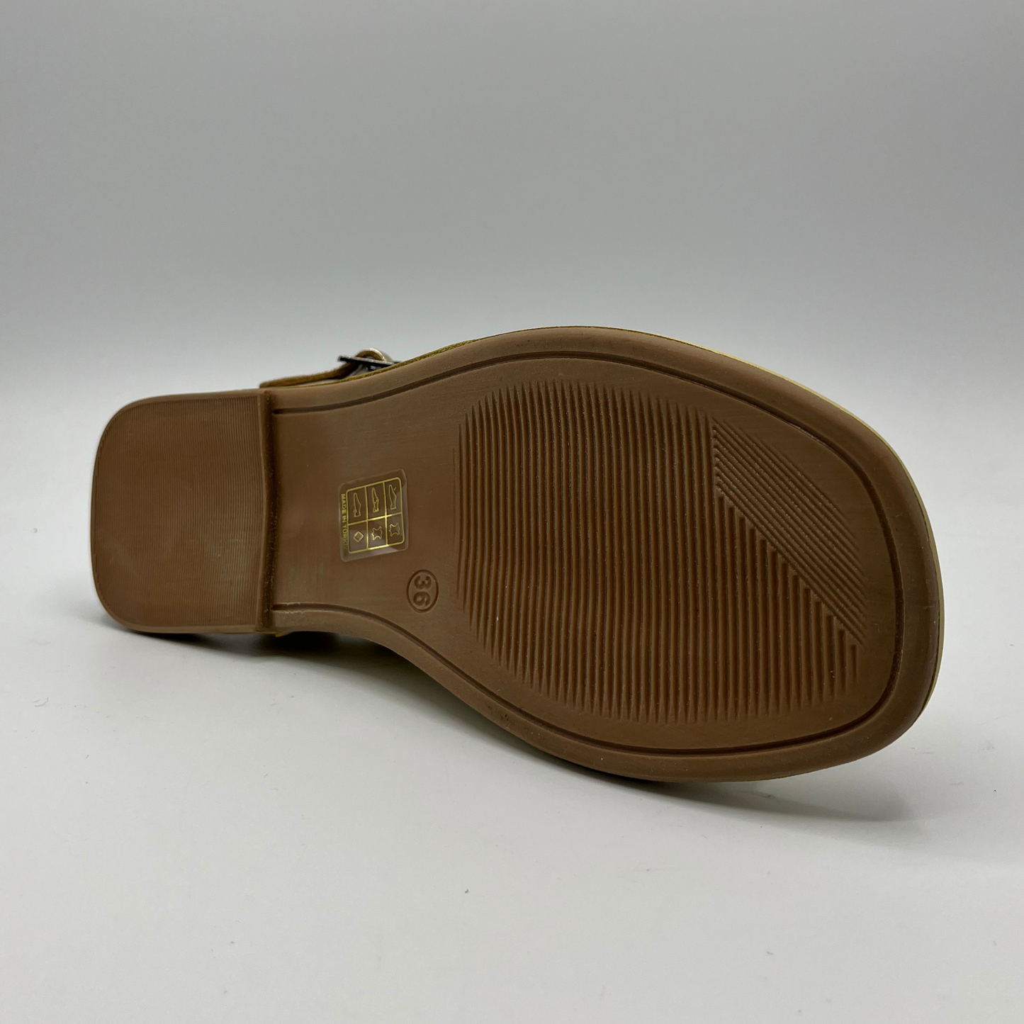 Bottom view of a leather sandal with a cushioned, leather lined insole and an adjustable ankle strap.