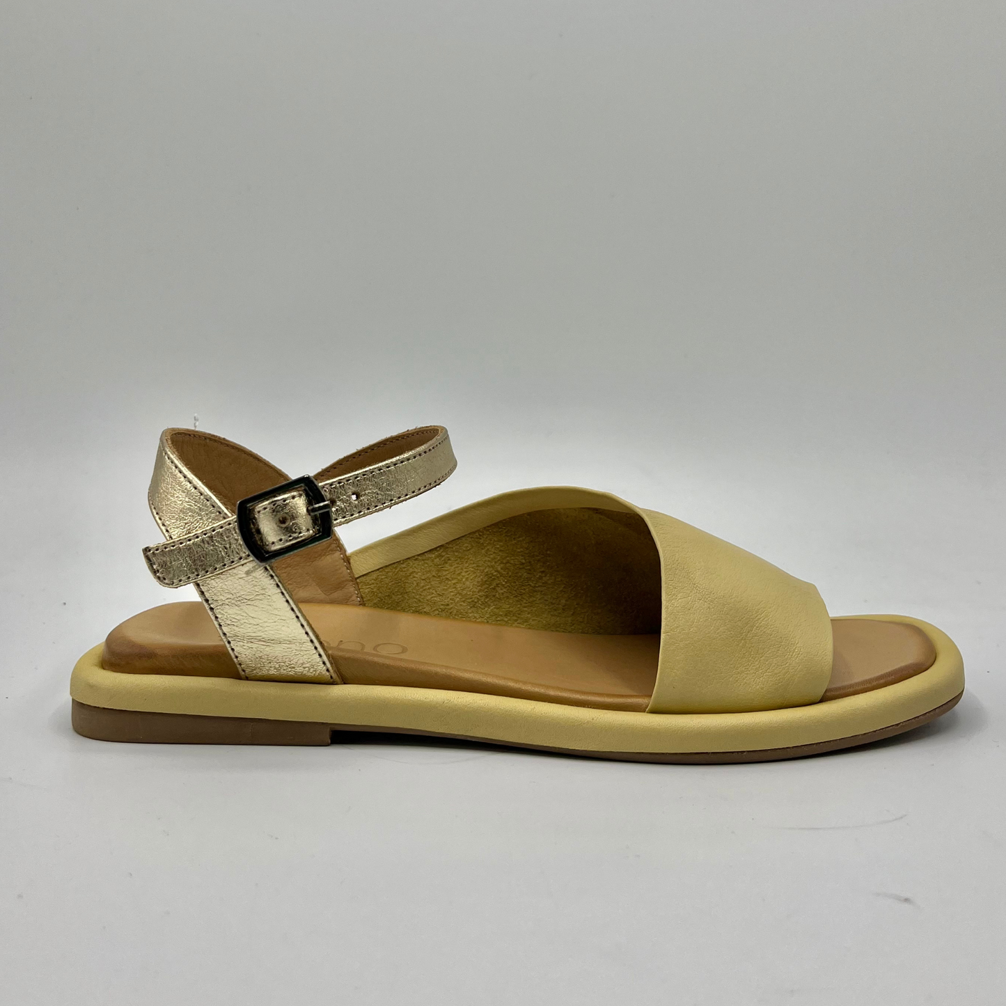 Right facing view of a leather sandal with a cushioned, leather lined insole and an adjustable ankle strap.