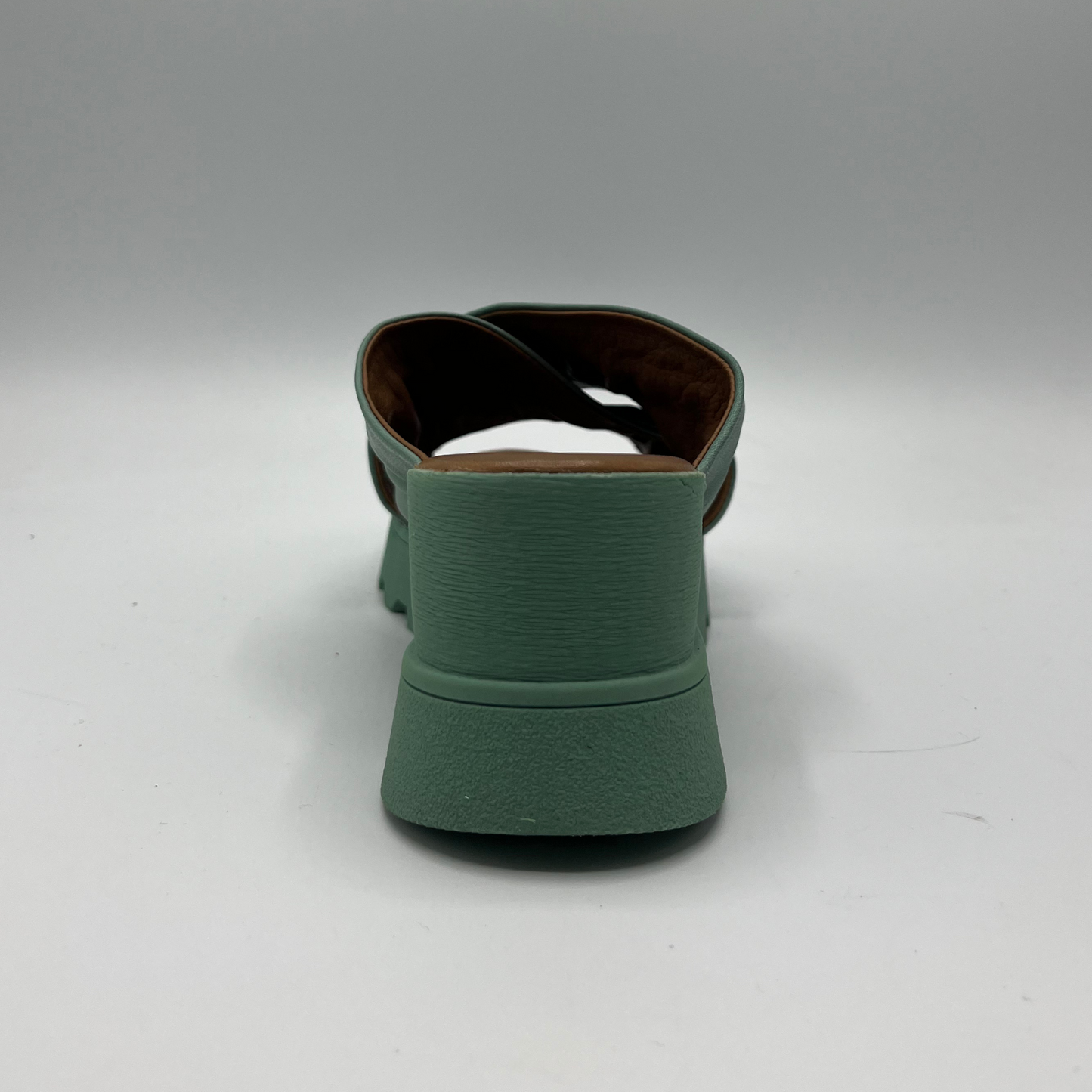 Back view of a leather slip on sandal in seafoam. Rouched cross strapped design and a wedge heel.