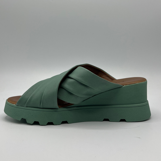 Left facing view of a leather slip on sandal in seafoam. Rouched cross strapped design and a wedge heel.