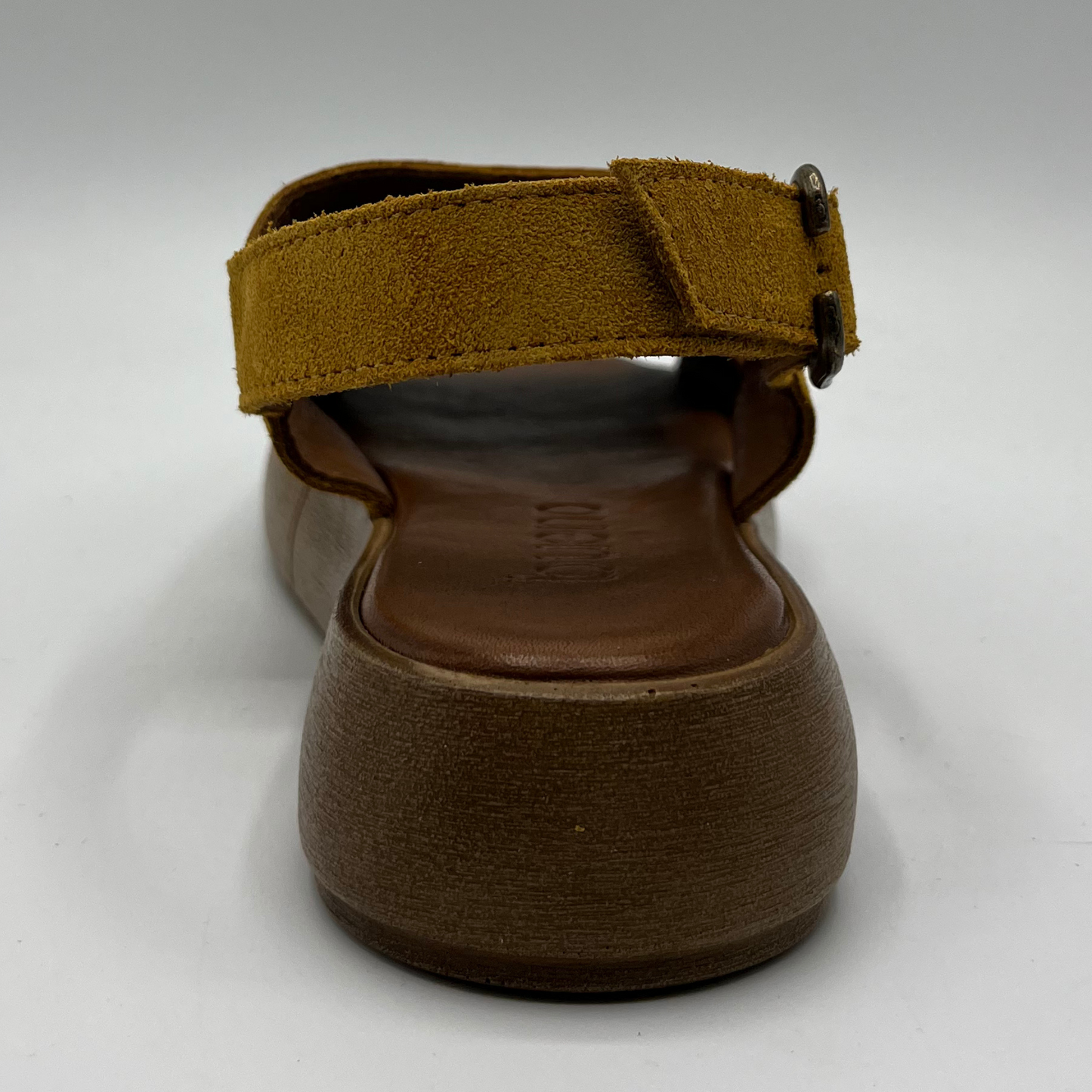 Back view of a mustard coloured suede sandal with a thick platform sole and an adjustable slingback strap.