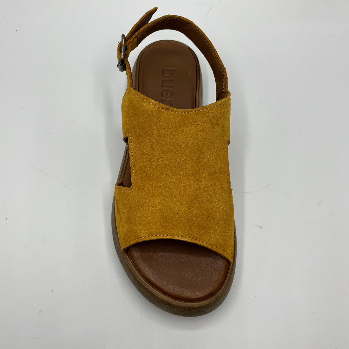 Top view of a mustard coloured suede sandal with a thick platform sole and an adjustable slingback strap.