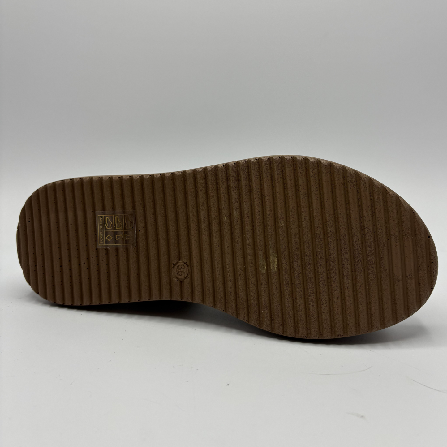 Brown shoe sole with visible brand logo on a white background