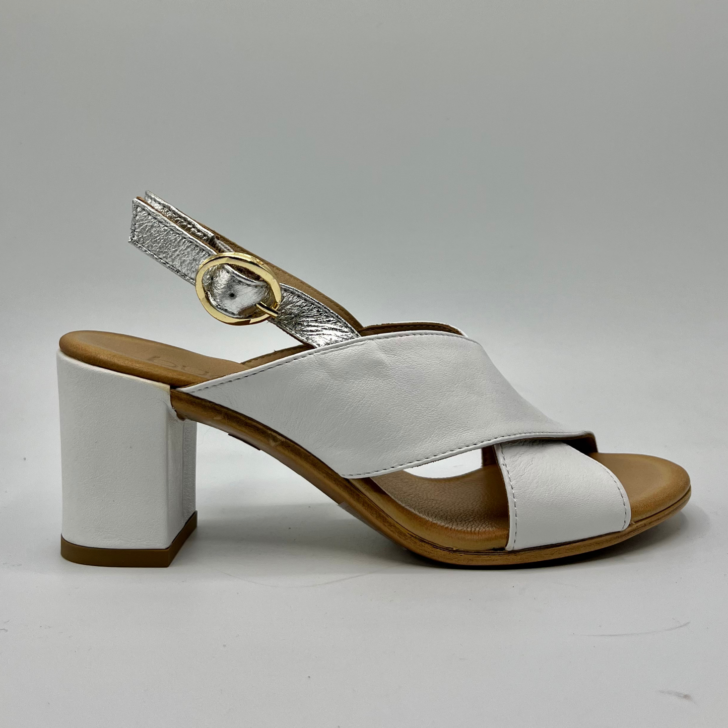 Right facing view of leather sandal with white straps. It has a block heel and a silver slingback strap